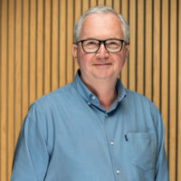 Headshot of man in blue shirt