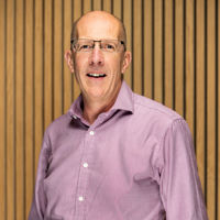 Headshot of man in pink shirt
